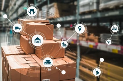 A stack of cardboard boxes in a warehouse with a digital overlay of interconnected logistics icons, including transportation, inventory, warehouse management, and tracking symbols, representing real-time monitoring and traceability in stock management.